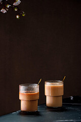 Sticker - Vertical shot of two cups of iced coffee on the black tabletop