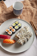 Wall Mural - Japanese sushi nigiri and rolls mix served on a white plate