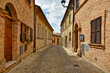 Narrow street between the old houses of Montecosaro, a medieval town in the Marche region of Italy