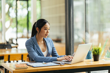 Wall Mural - Portrait of Asian young female working on laptop and financial report at office.