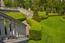 Stairs With Stone Railings Balusters And Iron Lanterns On The Background Of The Park With A Luxurious Landscape Design Walking Path For Walking