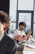 © LIGHTFIELD STUDIOS - Happy indian businessman talking to african american colleague in office.