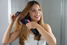 Young Woman Holds Round Brush Hair Dryer To Style Hair In An Easy Way At Home