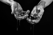 Women's Hands In A Viscous Liquid Similar To Blood. Black And White Photo.