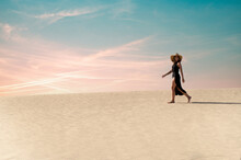 Traveler Walking In Desert At Sunset