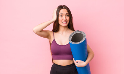 Wall Mural - hispanic pretty woman feeling stressed, anxious or scared, with hands on head. fitness and yoga concept