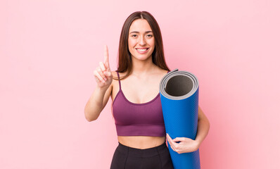 Poster - hispanic pretty woman smiling and looking friendly, showing number one. fitness and yoga concept