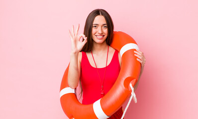 Poster - hispanic pretty woman feeling happy, showing approval with okay gesture. lifeguard concept