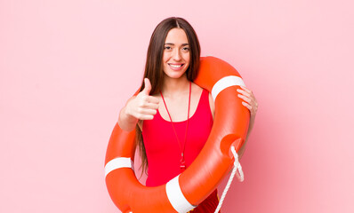 Wall Mural - hispanic pretty woman feeling proud,smiling positively with thumbs up. lifeguard concept