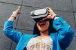 © Dani D.G - Young African woman using virtual reality goggles. Concept of future, metaverse, technology, innovation, surprise fun.
