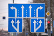 Traffic sign pointing multiple road lanes direction on city street. Signboard arrows for urban transport safety guidance