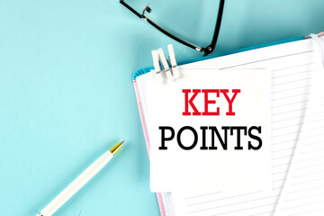 Poster - KEY POINTS text on a sticky on notebook with pen and glasses , blue background