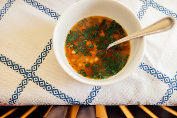 Sticker - White bean, carrot, Italian parsley soup in white bowl on blue and white tablecloth