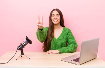 Wall Mural - hispanic pretty woman smiling and looking happy, gesturing victory or peace. influencer concept