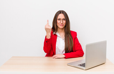 hispanic pretty woman feeling angry, annoyed, rebellious and aggressive.  business and desk concept