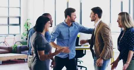 Canvas Print - Im so proud of all of you.Group of coworkers cheering and celebrating success in a modern office. Cheerful diverse group of businesspeople high fiving and celebrating in the office.