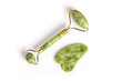 © Suraphol - Facial massage tool. Green quartz jade roller on white background. Trendy beauty tool concept. top view