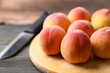 Peach fruit on cutting wooden board with knife