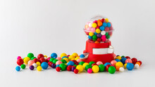 A Plastic Toy Gum Ball Machine Filled And Surrounded By Gum Balls.
