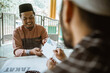 © Odua Images - portrait of happy muslim man paying zakat for eid mubarak at the mosque