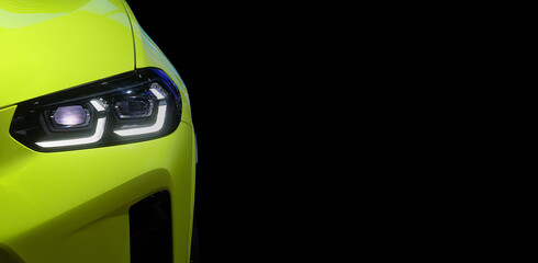 Close-up front headlight with LED xenon light of modern light green EV Car on black color background and copy space