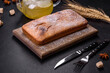 Baked rectangular cupcake with raisins and chocolate on a dark concrete background