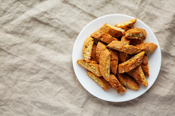 Wall Mural - Homemade Italian Cantuccini with Almonds on a White Plate, top view. Crispy Almond Cookies. Flat lay, overhead, from above. Space for text.