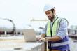 © manit - Heavy-duty industrial engineers stand in a pipeline manufacturing facility using digital tablet computers for the construction of products to transport oil, gas and fuel.