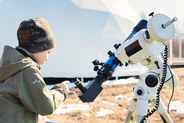 Wall Mural - child boy near the telescope on a tripod at the observatory for observation of stars and planets. sc