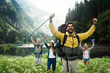Wall Mural - group of happy hiker friends trekking as part of healthy lifestyle outdoors activity