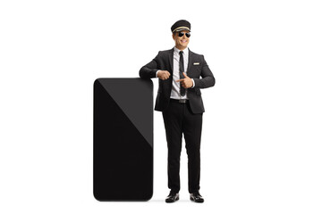 Wall Mural - Professional chauffeur leaning on a big mobile phone and pointing