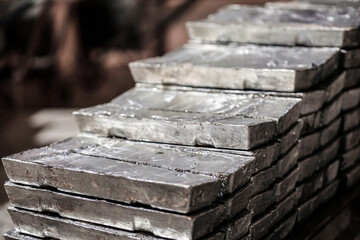Close-up of a pile of zinc ingots. Raw materials for the smelting industry. Aluminum, tin, iron. Rough metal bricks.