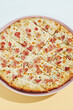 © Ryzhkov - Italian pizza with bacon and cheese on coloured background. Cheese focaccia with bacon in minimal style on blue colour. American pizza delivery concept with color backdrop