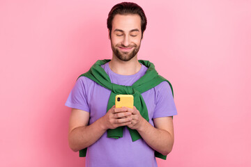 Wall Mural - Photo of handsome good mood male chatting with girlfriend in social network isolated on pink color background