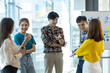 © Wasan - Colleagues gathered in the office stand together to share ideas from work ideas.