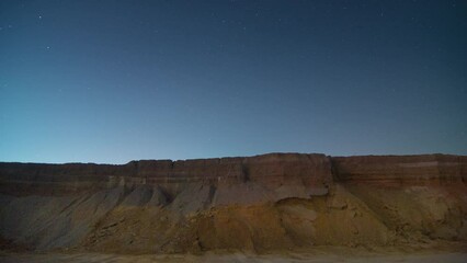 Wall Mural - 4k time-lapse video motion of night sky with circular star trails over the rock formations mountains