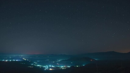 Wall Mural - 4K Time-Lapse Video motion of night sky with circular star trails over mountains foreground Pang Puai, Mae Moh, Lampang, Thailand.