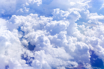 Wall Mural - white fluffy clouds below. top view from the window of an airplane flying in the clouds. selective f