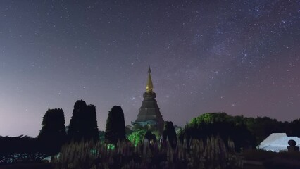 Wall Mural - time lapse 4k of star trails moving over a sacred temple at doi inthanon national park, chiang mai, 