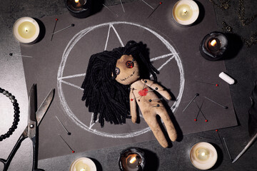 Wall Mural - Female voodoo doll pierced with pins and ceremonial items on grey table, flat lay