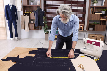 Wall Mural - Professional tailor with measuring tape working at table in atelier, space for text