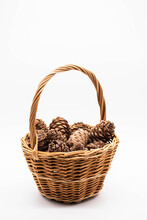 Cedar Cones With Pine Nuts In Wicker Basket On A White Background.