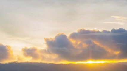 Wall Mural - time lapse 4k of sunrise over mountains with sunbeam light passing through the clouds in the beautif