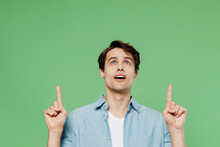 Jubilant Shocked Surprised Excited Young Brunet Man 20s Years Old Wear Blue Shirt Pointing Forefingers Overhead On Workspace Area Copy Space Mock Up Isolated On Plain Green Background Studio Portrait