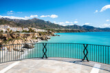 Fototapeta Uliczki - Travel destination, view on blue sea and mountains from Balcon de Europa in small Andalusian town Nerja with white houses and narrow streets on Costa del Sol, Spain