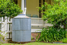 Sheet Metal Rain Barrel Next To Porch On Front Of House In New Orleans, Louisiana, USA