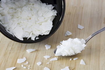 Soy wax - ingredient for handmade candles on black plate and white background	