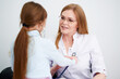© khmelev - Little girl patient checking heartbeats female doctor in hospital by stethoscope