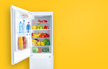Open Fridge Full Of Vegetables, Fruits And Drinks On Yellow Wall Background. Copy Space