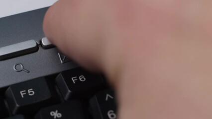 A man presses mail send button on a computer keyboard, the concept of hard work in the office